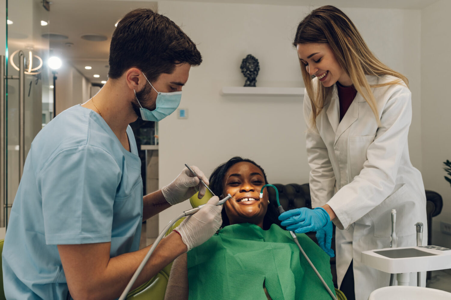 Dentist providing dental care treatment to a african american woman